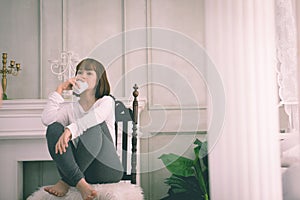 Beautiful Attractive Asian young woman sitting on wooden chair and relax with coffee after wake up in the morning