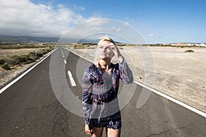 Beautiful attractive caucasian girl walk with a fashion dress on a long way road - horizon and travel concept with airplane flying