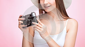 A beautiful, attractive female photographer holds a vintage camera. Tourism and travel concept