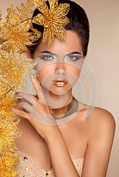 Beautiful Attractive Girl With Golden Flowers. Beauty Model Woman Face. Perfect Skin. Professional Make-up. Makeup.