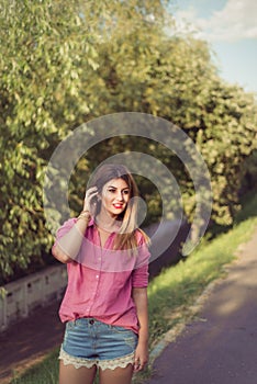 Beautiful and attractive woman moving her her aside, wearing casual denim shorts photo