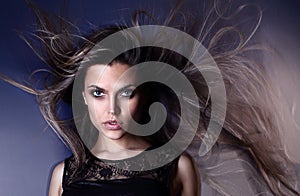 Beautiful attractive young Brazilian fashion model with hair blown by the air studio shot