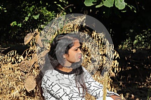 Beautiful attractive young Indian Hindu Woman model relaxing in the garden during summer