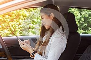 Beautiful attractive young woman smile in casual sitting in car using smartphone open GPS navigation app