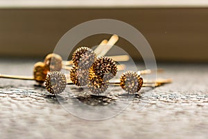 Beautiful automatic barrette with shiny stones and pink beads on dark textured background. Gold hairpins with white rhinestones.