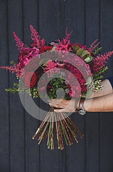 Beautiful autumn bouquet of red roses, red hydrangea macrophylla, king protea, astible japonica and other plants in the