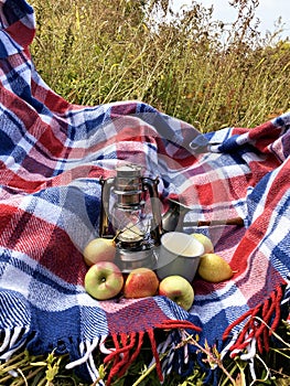 Beautiful autumn composition with vintage lantern, mug, coffee turk, blue red wool blanket, apples and pears