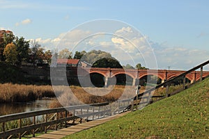 Beautiful autumn European landscape with old ancient bridge, river and wooden bridges on the beach, Kuldiga, Latvia