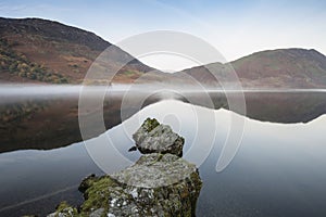 Beautiful Autumn Fall landscape image of Crummock Water at sunrise in Lake District England