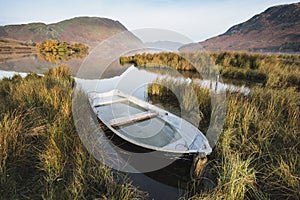 Beautiful Autumn Fall landscape image of Crummock Water at sunrise in Lake District England