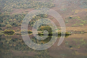 Beautiful Autumn Fall landscape image of Crummock Water at sunrise in Lake District England