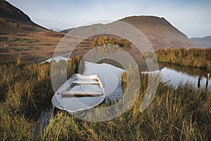 Beautiful Autumn Fall landscape image of Crummock Water at sunrise in Lake District England