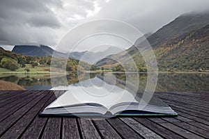 Beautiful Autumn Fall landscape image of Crummock Water at sunrise in Lake District England coming out of pages of book