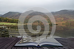 Beautiful Autumn Fall landscape image of Crummock Water at sunrise in Lake District England coming out of pages of book