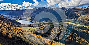 beautiful autumn hike above lake davos. Colored larch forests. Mountain panorama in Davos Klosters Mountains.