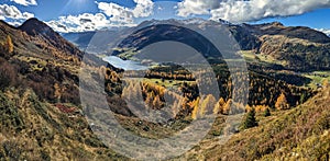 beautiful autumn hike above lake davos. Colored larch forests. Mountain panorama in Davos Klosters Mountains.