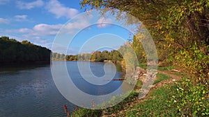 Beautiful autumn landscape, bright sunny day and forest, trees near river and blue sky