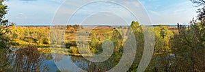 A beautiful autumn landscape with trees, a river and a field. When the hike is still warm, everything is already