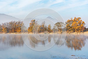 Beautiful autumn landscape with yellow trees and their reflection in the lake