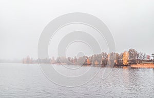 Beautiful autumn misty lake and forest wild landscape. Autumn forest and lake background