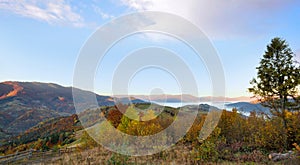 Beautiful autumn mountain landscape in the morning light with fog and bright hills. Carpathian, Ukraine