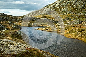 A beautiful autumn mountain landscape with a small lake. Natural scenery in Norwegian mountains.