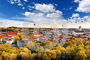 Beautiful autumn panorama of Vilnius old town with colorful hot air balloons in the sky