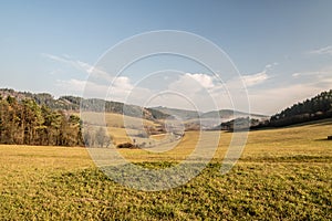 Beautiful autumn scenery with meadows, smalleer hills, dirt road and blue sky with clouds