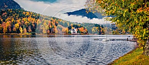 Panoramic autumn view of Grundlsee lake with small yacht.