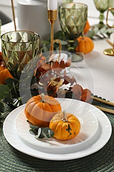 Beautiful autumn table setting. Plates, cutlery, glasses, pumpkins and floral decor