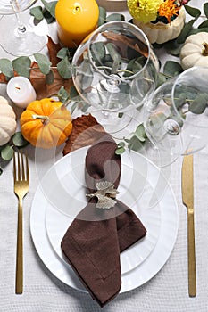 Beautiful autumn table setting. Plates, cutlery, glasses, pumpkins and floral decor, flat lay