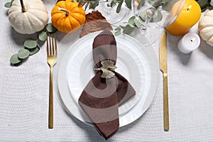 Beautiful autumn table setting. Plates, cutlery, glasses, pumpkins and floral decor, flat lay