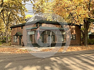 Beautiful autumn view and brick-made building with a US flag pole in front