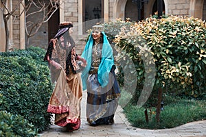 Beautiful azeri women in traditional Azerbaijani dress running by the wooden door photo