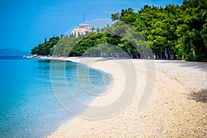 Beautiful azure blue Mediterranean beach surrounded by trees