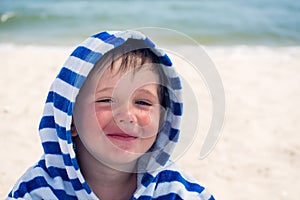 Beautiful baby with blue eyes on the sea background smiling, sweet and gentle. Cute child with atopic dermatitis