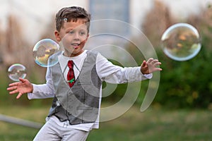 Beautiful baby boy with child soap bubbles posing photographer for cool photo