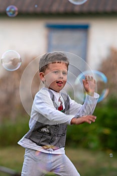 Beautiful baby boy with child soap bubbles posing photographer for cool photo