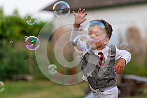 Beautiful baby boy with child soap bubbles posing photographer for cool photo