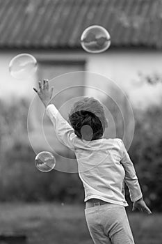 Beautiful baby boy with child soap bubbles posing photographer for cool photo