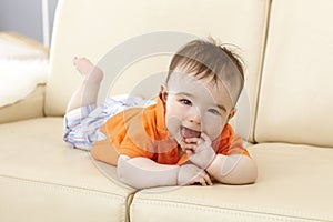 Beautiful baby boy lying on sofa