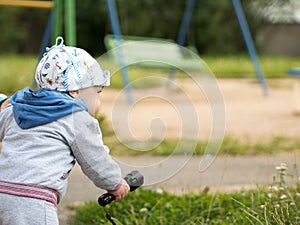 Beautiful baby boy playing on the playground with her mother. The is dressed in a light bike