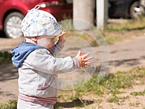 Beautiful baby boy playing on the playground with her mother. The is dressed in a light bike