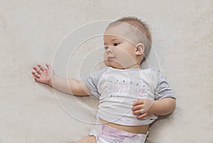 Beautiful baby in a diaper is lying on the bed