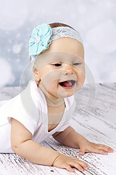 Beautiful baby girl crawling on the floor and laughing