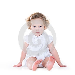 Beautiful baby girl with curly hair in nice white dress