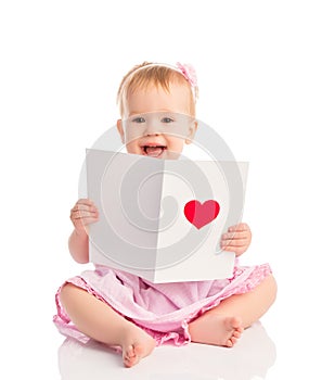 Beautiful baby girl with cute valentine postcard with a red hear