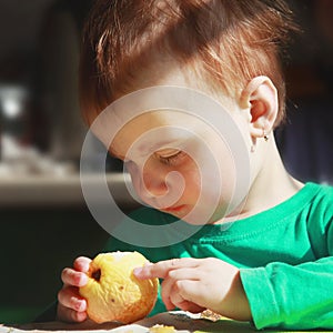 beautiful baby girl eats an apple (bio food, health, healthy lifestyle, vegetarian food)