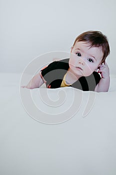 Beautiful baby girl in halloween costume at home, sitting on bed with Halloween decoration, Lifestyle indoors