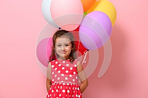 Beautiful baby girl, smiling looking at camera, isolated over pink background with copy space. Concept of happy childhood,